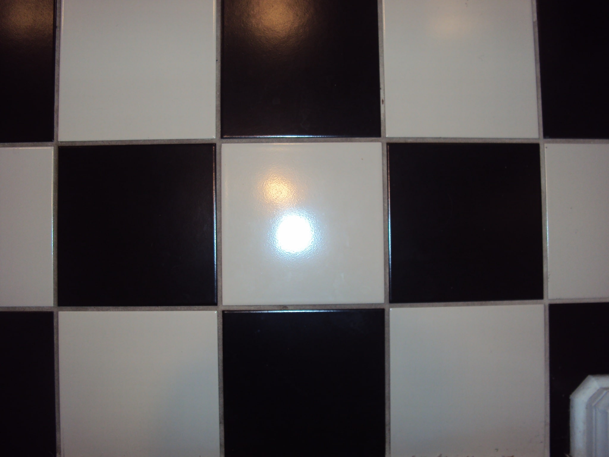 Polished black and white tile with a deep reflective shine